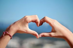 pexels-photo-356319-356319 Close-up of hands forming a heart shape with clear blue sky background.